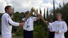 Spyridon Janniotis (L), řecký plavec, Alexander Loukos (R), britský boxer, si předávají olympijské světlo v řecké olympii. Olympijská pochodeň poputuje do Velké Británie