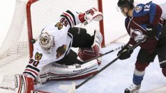 Brankář Blackhawks Corey Crawford zasahuje proti střele Chucka Kobasewaz Colorada