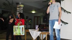 Herci Helena Karochová a Petr Florian draží ručně šitého dinosaura od dětí z nízkoprahového klubu Bedna
