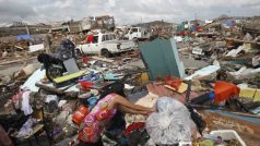 Žena si poblíž města Tacloban suší šaty na troskách tisíců zničených domů po průchodu supertajfunu Haiyan