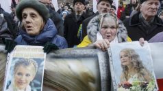 Protestující drží portréty uvězněné expremiérky Tymošenkové na proevropské demonstraci v Kyjevě