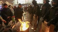 Protestující se v Kyjevě zahřívají u ohňů v přítomnosti pořádkových jednotek