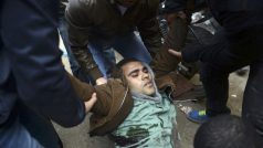 Stoupenci Muslimského bratrstva odnášejí zraněného demonstranta v Káhiře
