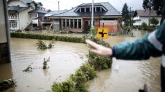 Muž ukazuje následky rozvodněné řeky ve městě Maglaj