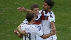 Sami Khedira (vpravo) a Mario Götze (vlevo) gratulují střelci hattricku Thomasi Müllerovi (uprostřed)