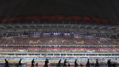 Čínští vojáci suší plochu stadionu během zahajovacího ceremoniálu olympijských her mládeže