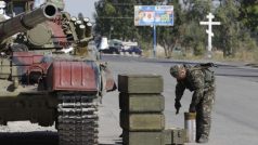 Ukrajinský technik nakládá munici do tanku na kontrolním stanovišti u města Mariupol