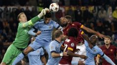 Kapitán fotbalistů Manchesteru City Joe Hart vyboxovává míč před dotírajícími protihráči