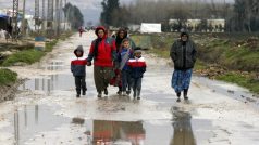 Syrští uprchlíci procházejí kolem provizorní osady ve východním Libanonu