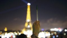 Účastník shromáždění v pařížských ulicích drží pero jako symbol svobody projevu