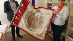 Michal Doležel (za Sokol Brno I) a Barbora Hejlová (za restaurátorskou dílnu) drží sokolský prapor