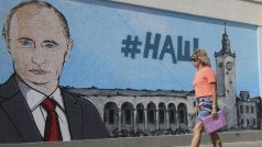 Žena v krymském Simferomolu prochází kolem graffiti, které znázorňuje ruského prezidenta Vladimira Putina