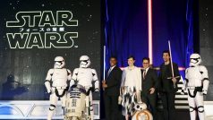 Star Wars. Zleva bílí vojáci Impéria, takzvaní stormtroopeři, herci  John Boyega a Daisy Ridleyová, režisér J. J. Abrams a herec Adam Driver. V popředí vlevo robot R2-D2 a vpravo nový BB-8