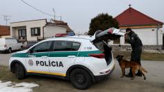 Policista se služebním psem před domem, kde Ján Kuciak a jeho snoubenka Martina Kušnírová žili a byli zavražděni (Veľká Mača, 27. února 2017).