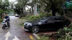 Muž projíždí ulicí plné popadaných stromů v čínském městě Šen-čen