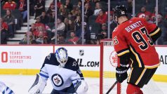 Brankář Winnipeg Jets Mikhail Berdin zastavuje střelu útočníka Calgary Flames Sama Bennetta