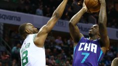 Kemba Walker (vlevo) blokuje střelecký pokus Dwayna Bacona