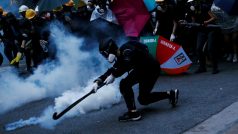 Demonstrant se snaží odpálit zpět  kapsli se slzným plynem, který policie v Hongkongu použila k rozehnání  demonstrace proti zákonu o národní bezpečnosti navrhovanému Pekingem.