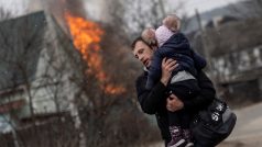 Muž s dítětem po těžkém ostřelování unikají z města Irpiň po jediné únikové cestě používané místními obyvateli, zatímco ruské jednotky postupují směrem k hlavnímu městu Kyjev