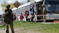 Civilisté z oblasti nedaleko Azovstalu nastupují do autobusu v dočasném ubytovacím centru u obce Bezimenne