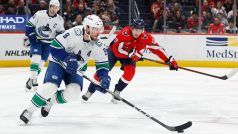 Dylan Strome z Washington Capitals pronásleduje J.T. Millera z Vancouver Canucks