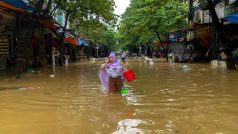 Žena se brodí zaplavenou ulicí po úderu tajfunu Yagi ve městě Thai Nguyen ve Vietnamu, 11. září 2024