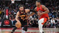 Trae Young z Atlanty Hawks prochází přes guarda Toronta Raptors Ochaie Agbajiho