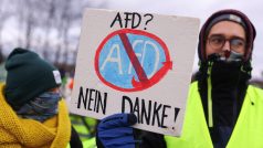 Protestující drží nápis „AfD? Ne, díky“, když se účastní demonstrace blokující silnici.