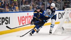 Adam Lowry z Winnipegu (v bílém) se snaží vypíchnout puk obránci St. Louis Justinu Faulkovi