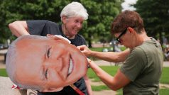 Ženy připravují banner s tváří exprezidenta Bidena na demonstraci v den vojenské přehlídky a Trumpových narozenin ve Washingtonu (14. června 2025)