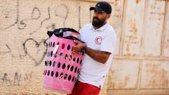 Paramedik pomáhá Palestincům přenášet osobní věci během izraelské vojenské operace nedaleko uprchlického tábora Jenin na Izraelem okupovaném Západním břehu Jordánu (8. července 2025)