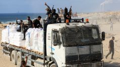 Palestinci z ozbrojených klanů jedou na kamionu s humanitární pomocí
