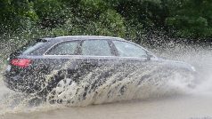 Automobil projíždí zaplavenou silnicí poblíž Černošic.
