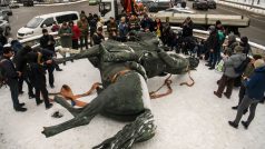 Lidé a novináři si prohlížejí a fotografují pomník Mykoly Šorse, jednoho ze sovětských bolševických vojenských velitelů během sovětsko-ukrajinské války v letech 1917-1921, po jeho demontáži v Kyjevě