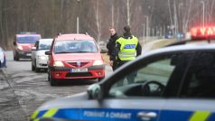 Policista hovoří s řidičem osobního vozu při příjezdu k policejní uzavírce na silnici do Poličky