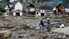 Muž a hasič prochází troskami v německém městě Schuld