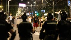 Protestující stojící proti těžkooděncům během demonstrací v Bělehradě