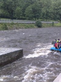 Vodáci sjíždějí jez u Papouščí skály na řece Vltavě