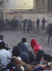 Protestující stojí proti kordonu policie v ulici blízko káhirského náměstí Tahrír