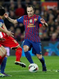 Andrés Iniesta se snaží proniknout mezi hráči Gijónu v Primera División