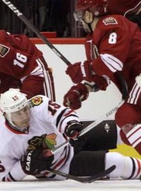 Chicago Blackhawks left wing Andrew Brunette (15) is hit to the ice by Phoenix Coyotes center Gilbert Brule (8) and defenseman Rostislav Klesla  (16) during Game 1 of the NHL Western Conference quarter-final hockey playoffs