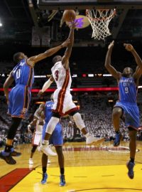 Miami Heat&#039;s Dwyane Wade (C) shoots between Oklahoma  City Thunder&#039;s Russell Westbrook  (L) and Serge Ibaka (R) in the first half during Game 4 of the NBA basketball finals in Miami, Florida, June 19, 2012