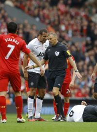 Hráč Manchesteru United Jonny Evans leží na trávníku po střetu s liverpoolským Jonjo Shelveym