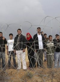 Palestinci stojící  u plotu, který odděluje pásmo Gazy od Izraele