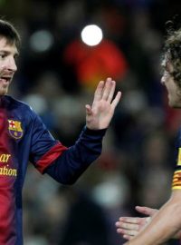 Fotbalista Barcelony Lionel Messi (vlevo) a jeho spoluhráč Carles Puyol slaví gól do sítě Osasuny ve španělské lize