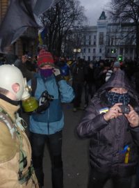 Lidé si dění před prezidentským palácem v Kyjevě natáčejí