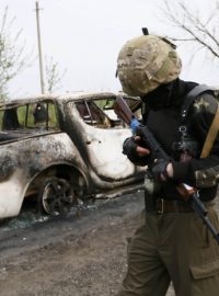 Proruský separatista hlídkuje nedaleko kontrolního stanoviště, kde došlo k přestřelce (Ukrajina, Slavjansk)