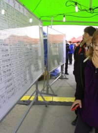 Příbuzná cestujícího z potopeného jihokorejského trajektu Sewol sleduje oficiální seznam obětí nehody v přístavu na ostrově Džindo