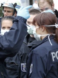 Němečtí policisté v ochranných maskách v berlínské čtvrti Pankow