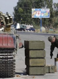 Ukrajinský technik nakládá munici do tanku na kontrolním stanovišti u města Mariupol